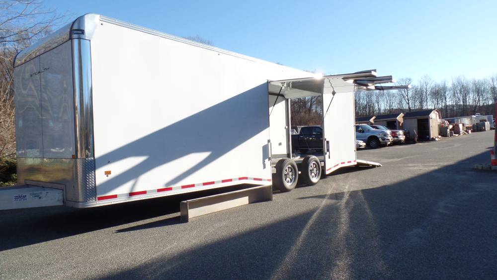 USED 2023 Pre Owned, 8.5X28 enclosed car trailer, Aluminum Frame, Escape Door with Removable Fender, Airline Track Recessed in Floor, Finished Interior, 14,000 lb. GVWR, Torsion Axles. Cabinets, Electric, Rubber Coin Floor